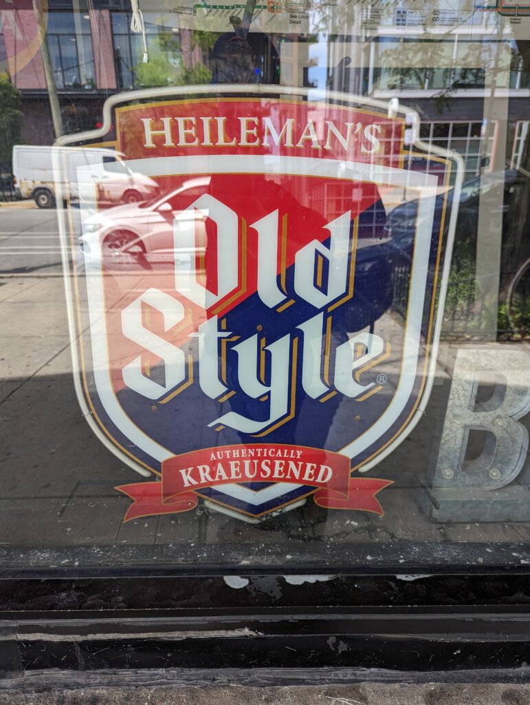 A sign with the logo of Heileman's Old Style, with the slogan "Authentically Kraeusened".