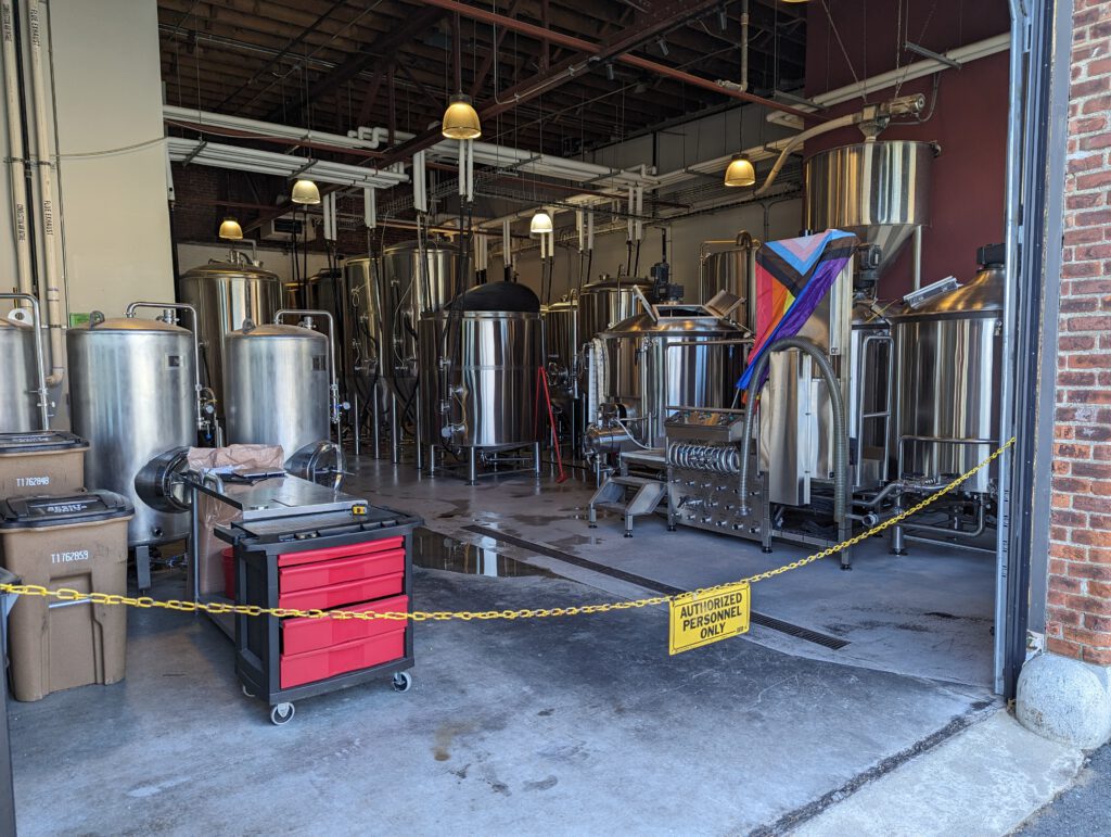 The view from the outside into the brew house at Notch in Salem. While the gate is open, access is blocked off with a yellow chain and a sign saying "Authorized Personnel Only".