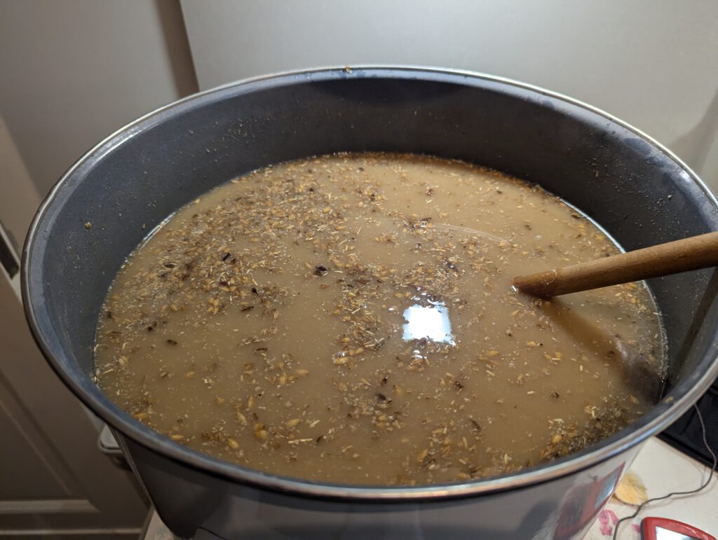 The main mash after the decoction portion has been mixed back in, noticeably darker than the main mash before mixing back.