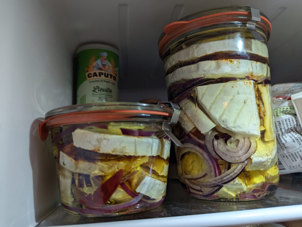 Two jars of home-made nakládaný hermelín maturing in my fridge.