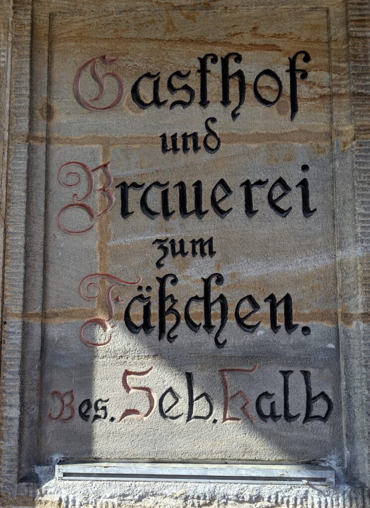 Sign hewn into stone outside Fässla brewery, saying "inn and brewery zum Fäßchen, owner Seb[astian] Kalb"